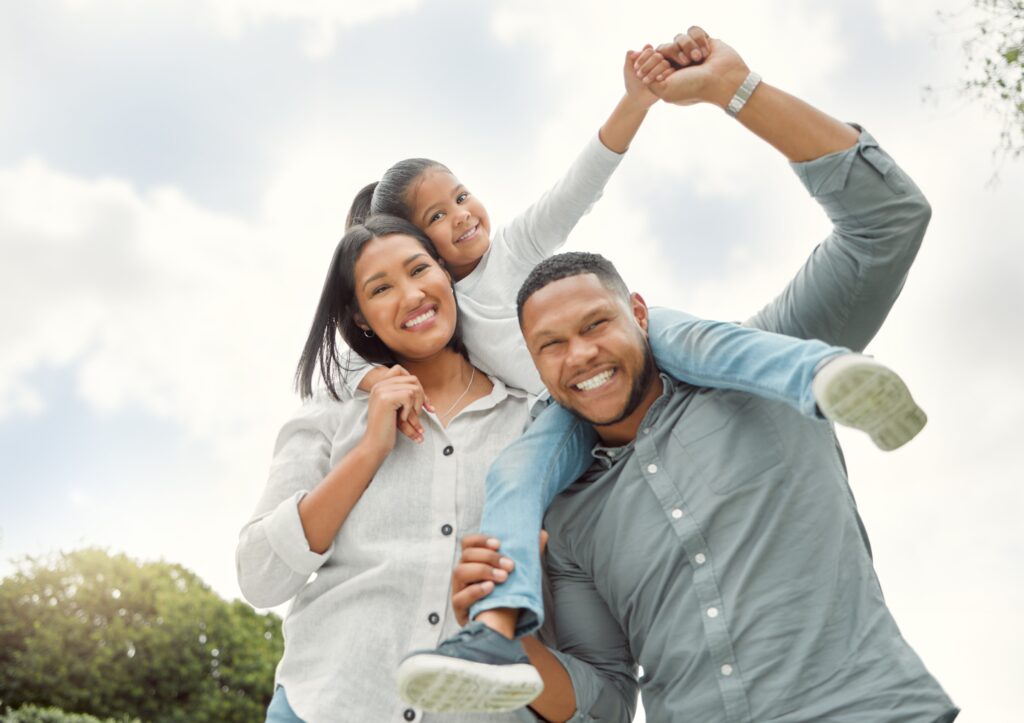 Parents, girl happy outside with shoulder ride