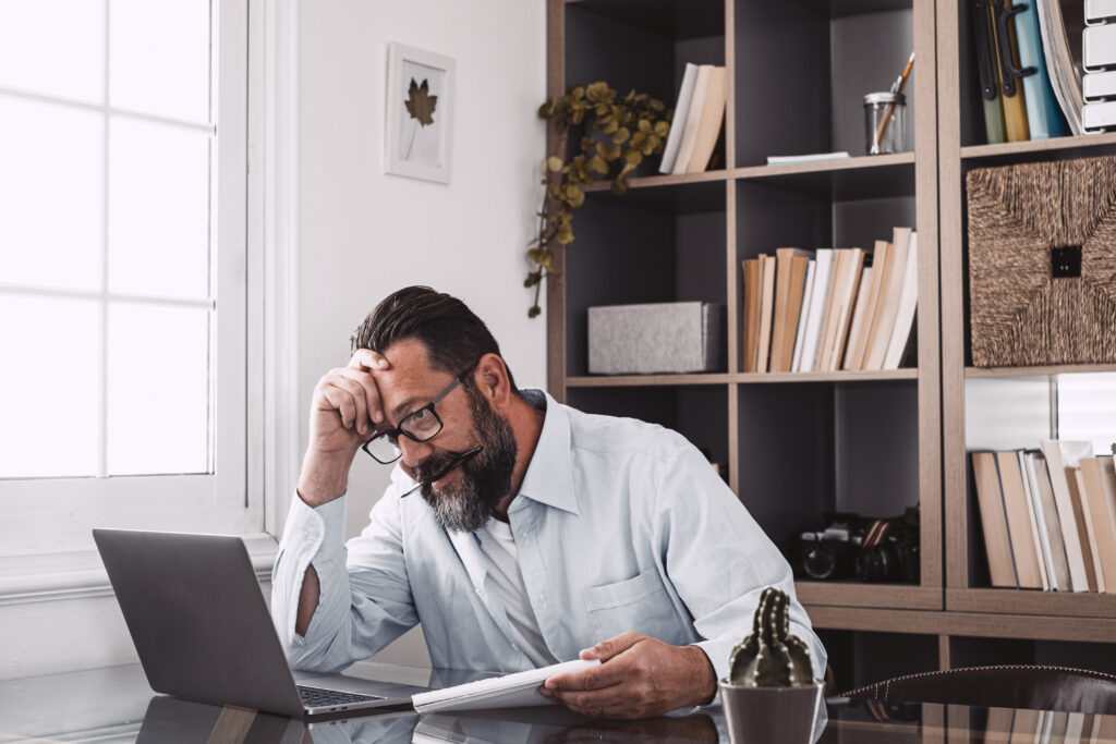 Stressed man looking at computer