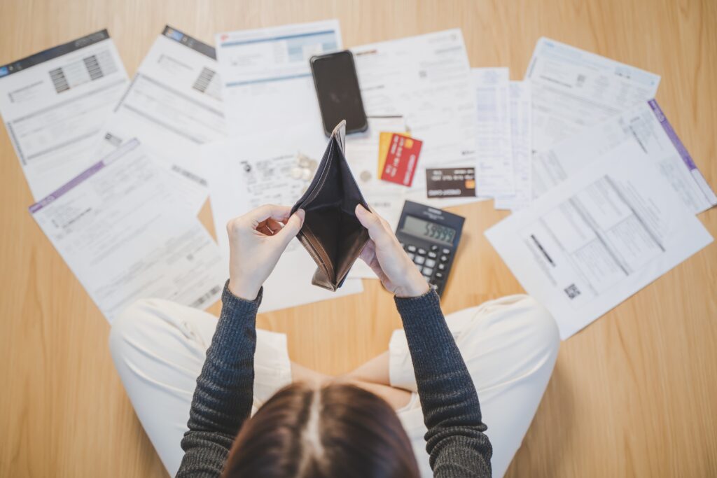 Top view of stressed woman opening wallet to find money to pay credit card debt